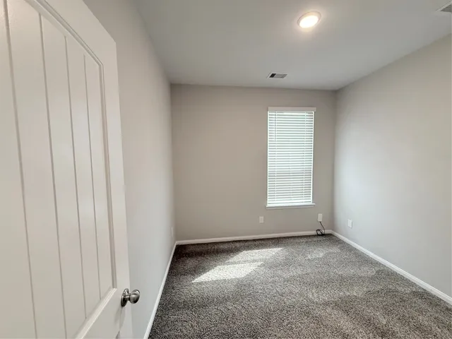 an empty room with closet and mirror