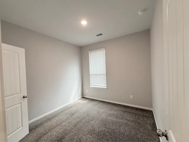 an empty room with closet and mirror