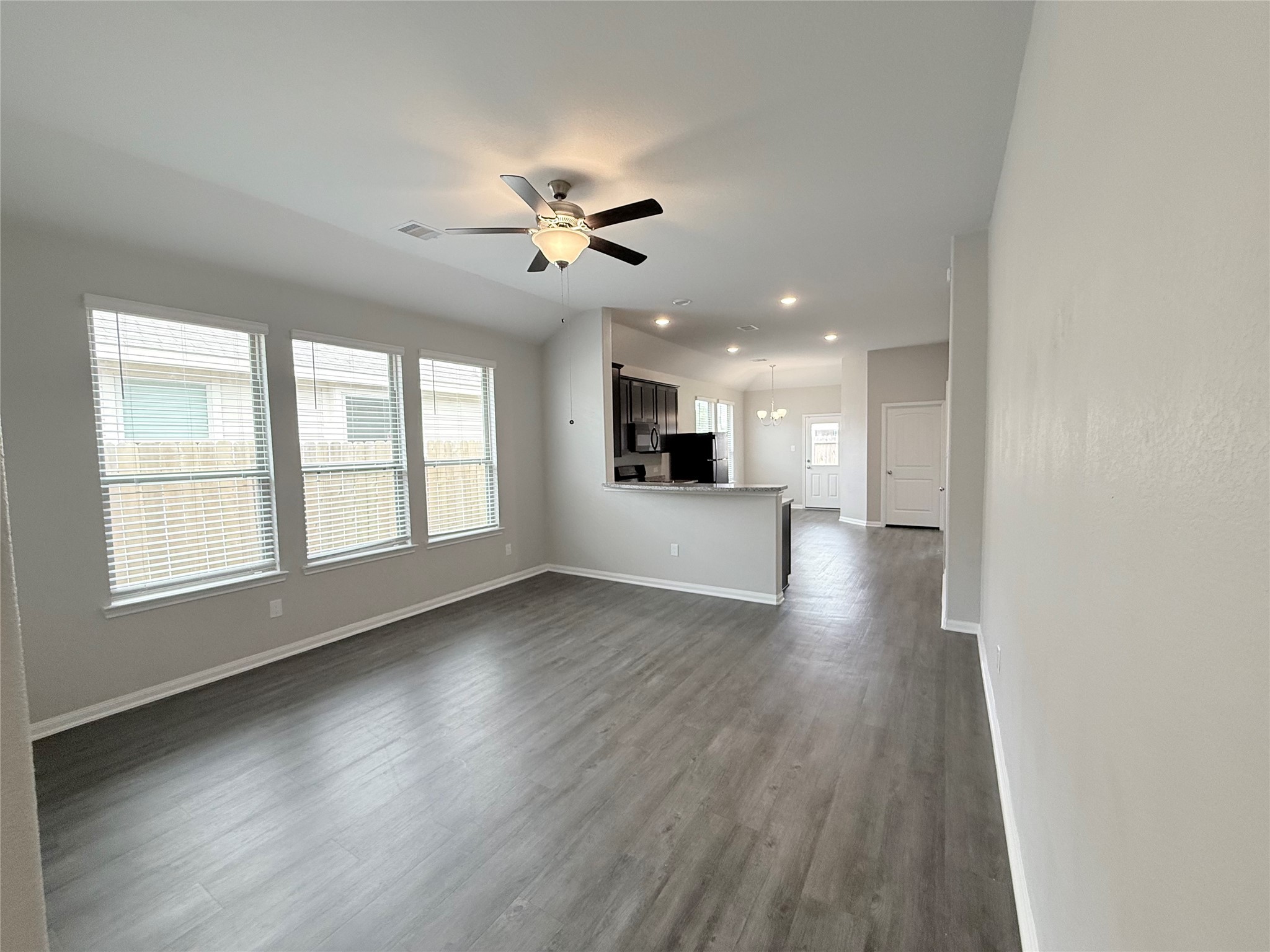 14501 Sugar Pines Drive Conroe, TX 77302 - Photo 6 of 46 a view of an empty room with a kitchen and wooden floor