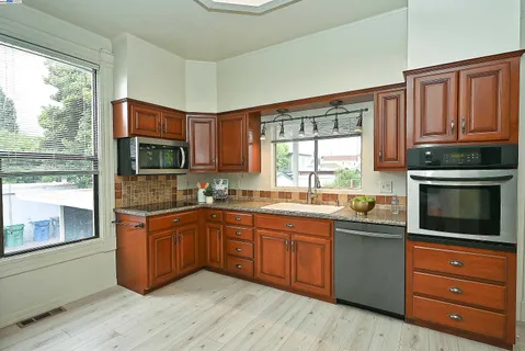 a kitchen with stainless steel appliances granite countertop a stove sink and microwave