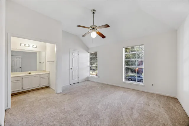 a view of an empty room with a window and a kitchen