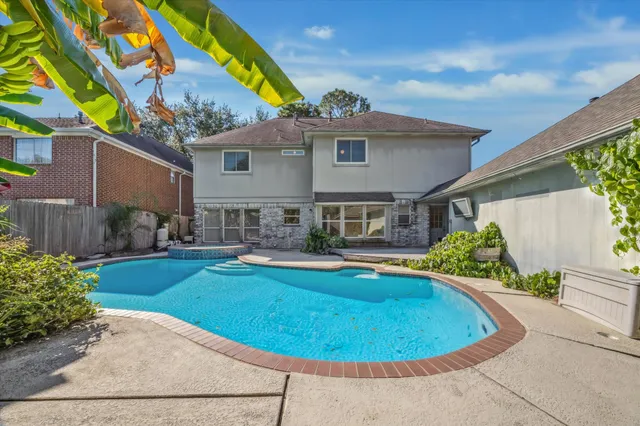 a view of a house with swimming pool and sitting area