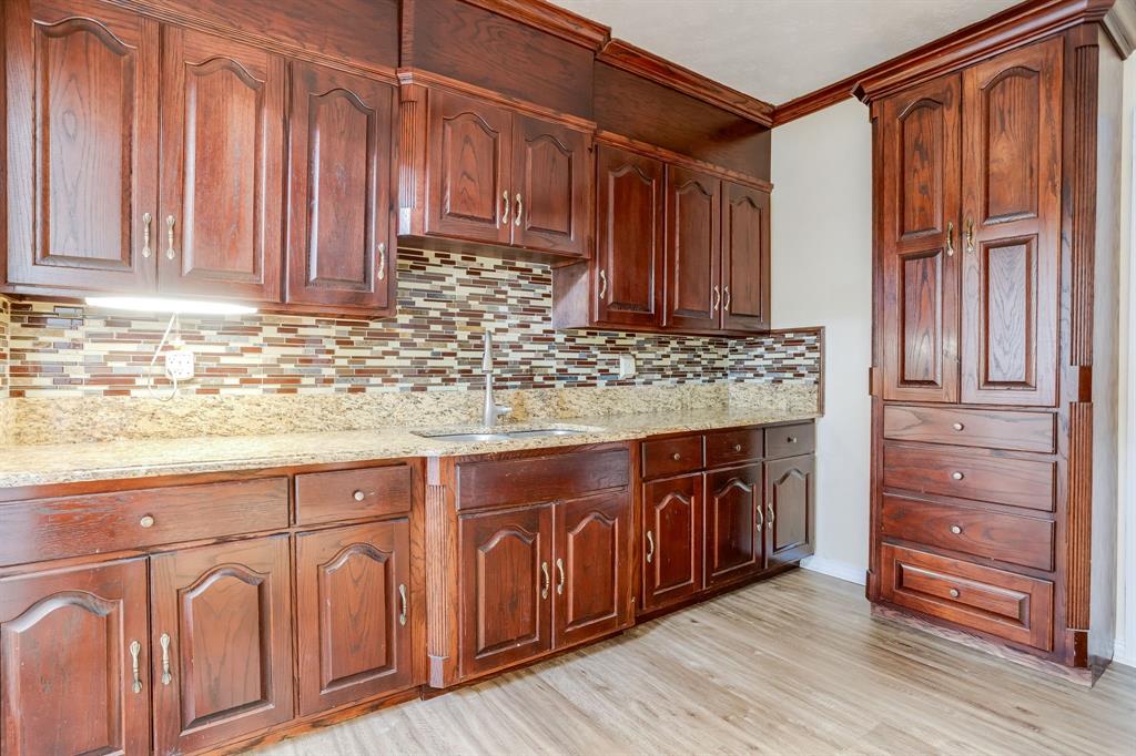 644 North Tyler Street Dallas, TX 75208 - Photo 12 of 33 a kitchen with granite countertop wooden cabinets a sink and dishwasher