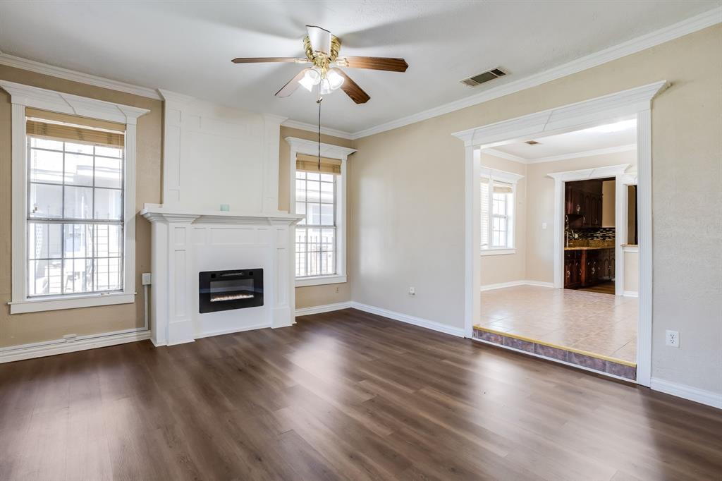 644 North Tyler Street Dallas, TX 75208 - Photo 4 of 33 a view of an empty room with wooden floor fireplace and a window