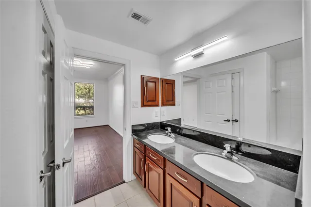 a bathroom with a granite countertop sink and a mirror