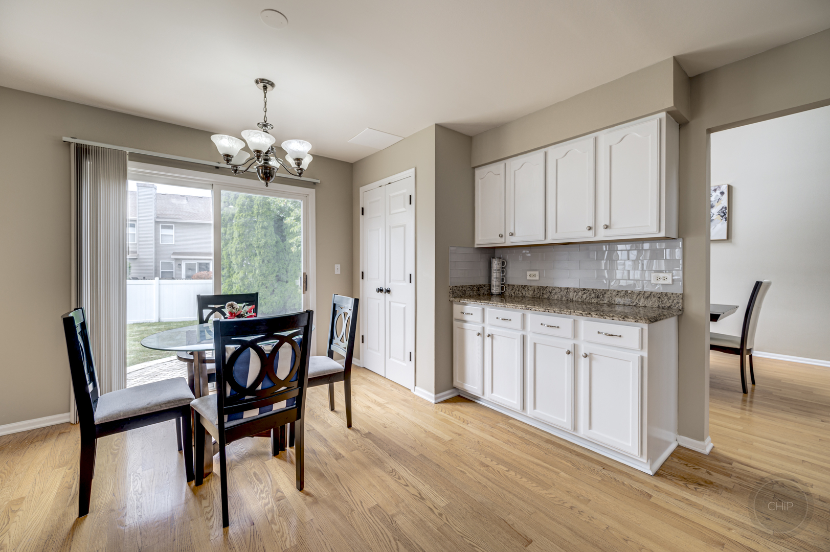 2135 Skylane Drive Naperville, IL 60564 - Photo 11 of 44 a kitchen with granite countertop wooden floor cabinets dining table and stainless steel appliances