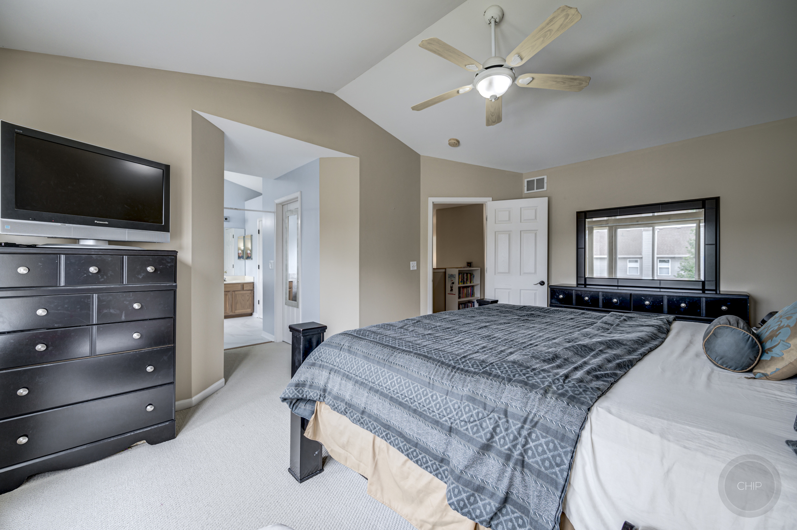 2135 Skylane Drive Naperville, IL 60564 - Photo 22 of 44 a bedroom with a bed a mirror and flat screen tv