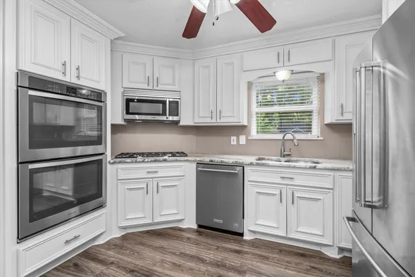 a kitchen with stainless steel appliances granite countertop a stove a microwave and a refrigerator