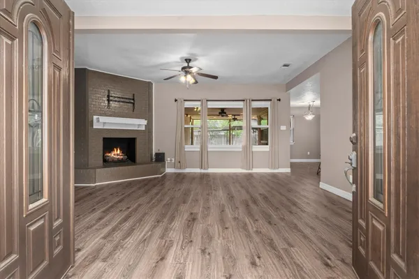 a view of empty room with wooden floor and fireplace