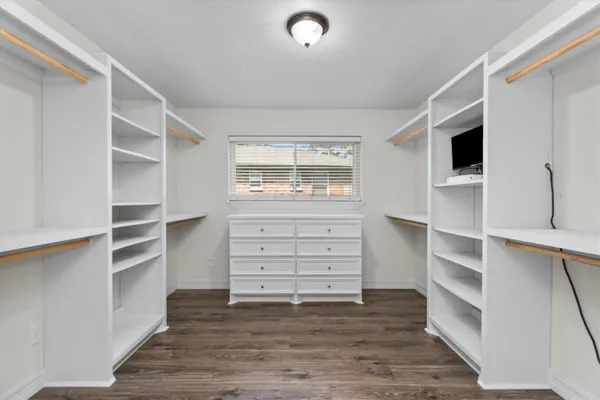 a view of walk in closet with clothes and shoes
