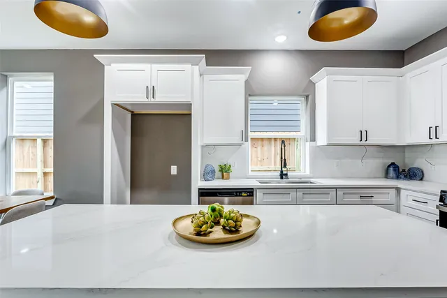 a kitchen with stainless steel appliances granite countertop a sink a window and a counter space