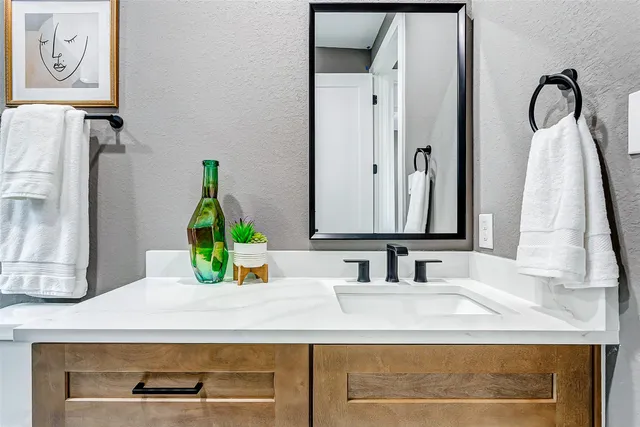 a bathroom with a granite countertop sink toilet and shower