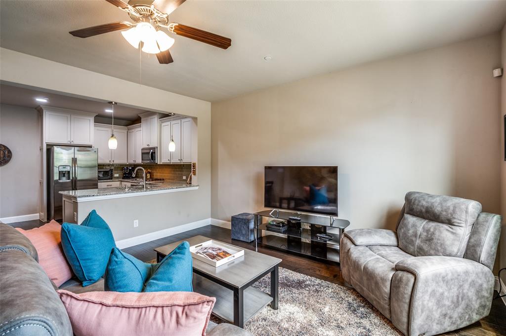 4665 Dozier Road, Unit C Carrollton, TX 75010 - Photo 5 of 26 a living room with furniture and a flat screen tv with kitchen view
