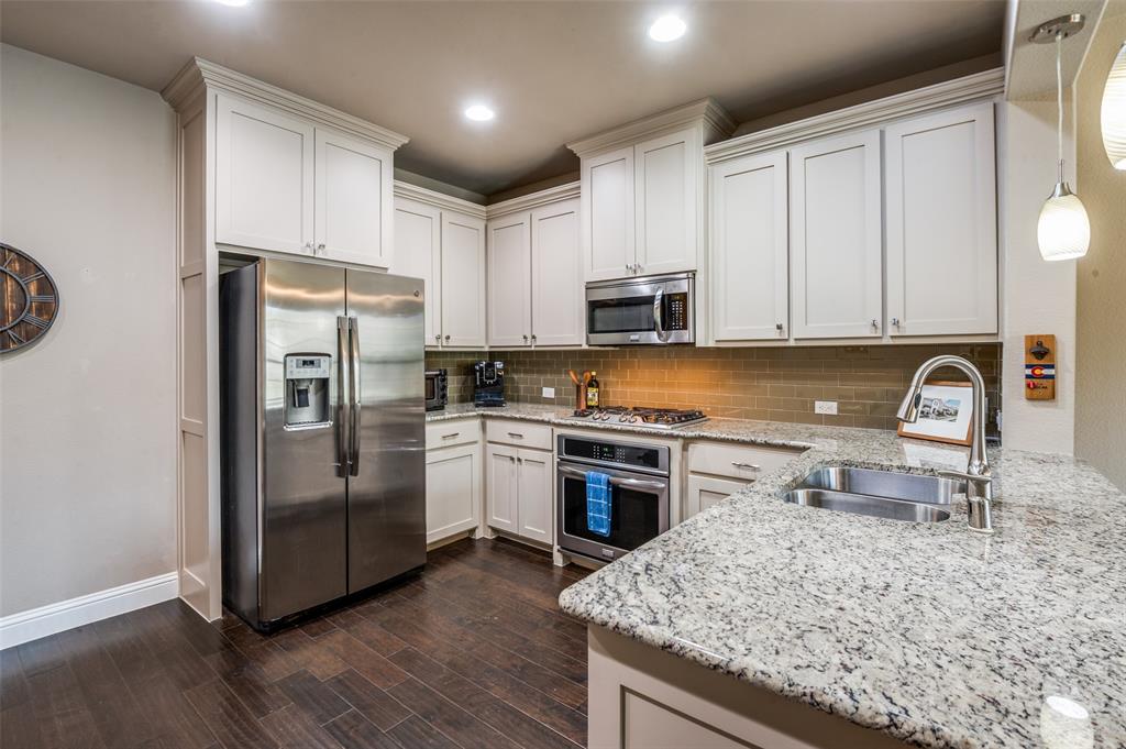 4665 Dozier Road, Unit C Carrollton, TX 75010 - Photo 7 of 26 a kitchen with stainless steel appliances granite countertop a refrigerator stove microwave and sink
