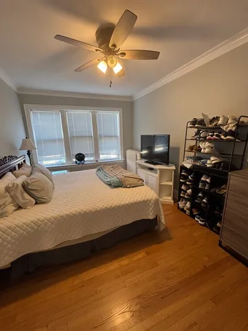 a bedroom with a bed a chandelier and a television