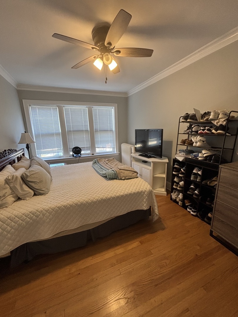 500 Spring Road, Unit 1 Elmhurst, IL 60126 - Photo 5 of 6 a bedroom with a bed a chandelier and a television