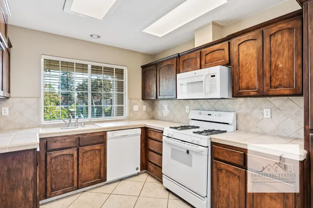a kitchen with cabinets appliances and a window