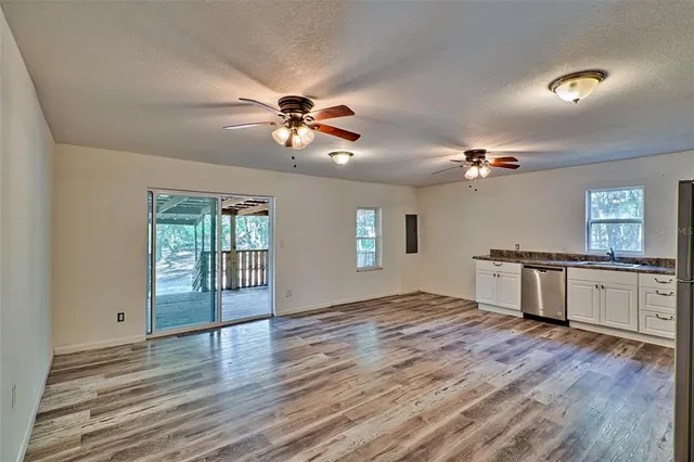 wooden floor in an empty room with a kitchen
