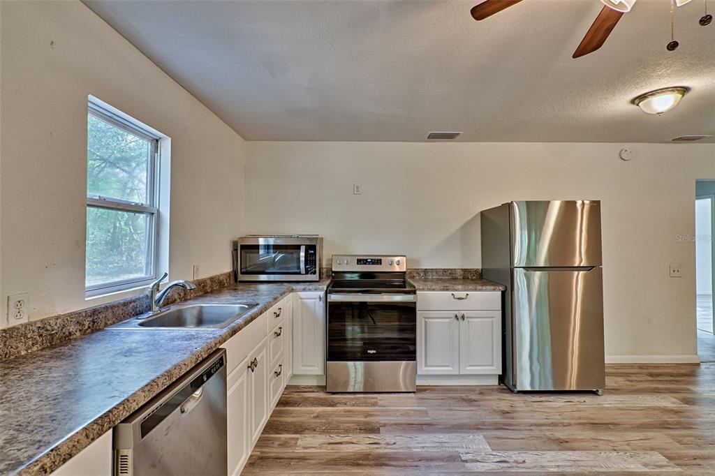 300 South Us Highway Bell, FL 32619 - Photo 9 of 47 a kitchen with a center island wooden floor and stainless steel appliances