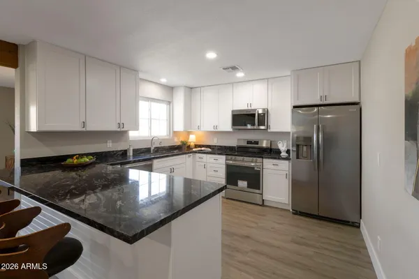 a kitchen with a refrigerator a microwave a sink and cabinets