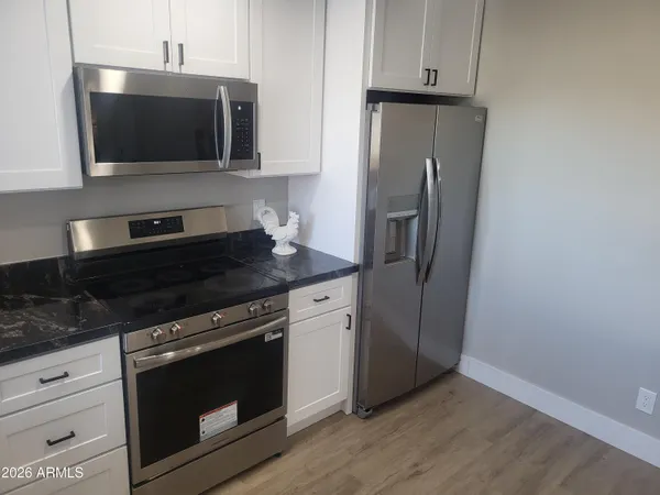 a kitchen with stainless steel appliances wooden cabinets and a stove top oven