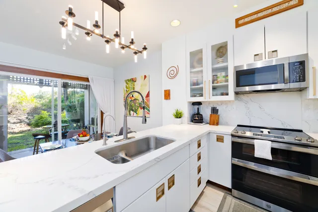 a kitchen with stainless steel appliances granite countertop a sink stove and cabinets