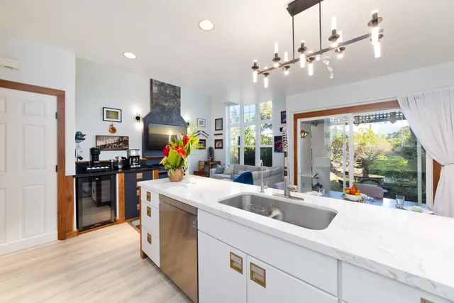 a kitchen that has a lot of cabinets stainless steel appliances and a large window