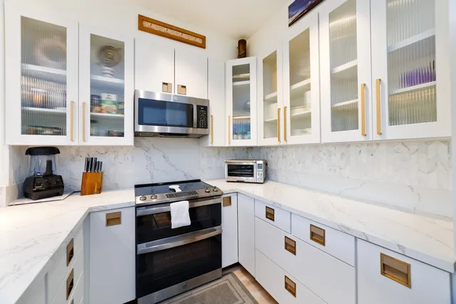 a kitchen with stainless steel appliances a stove and a microwave