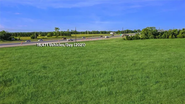 a view of a field with an trees in the background