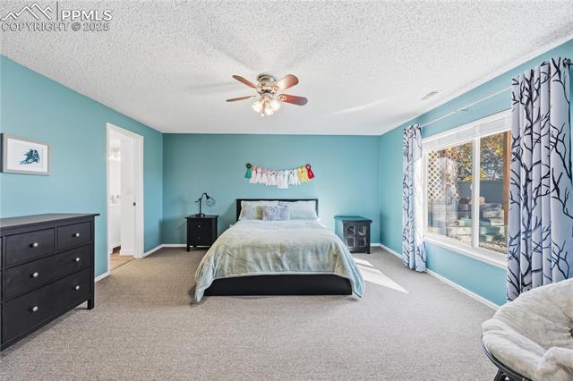 2135 Glenhill Road Colorado Springs, CO 80906 - Photo 39 of 50 Carpeted bedroom featuring ceiling fan and a textured ceiling