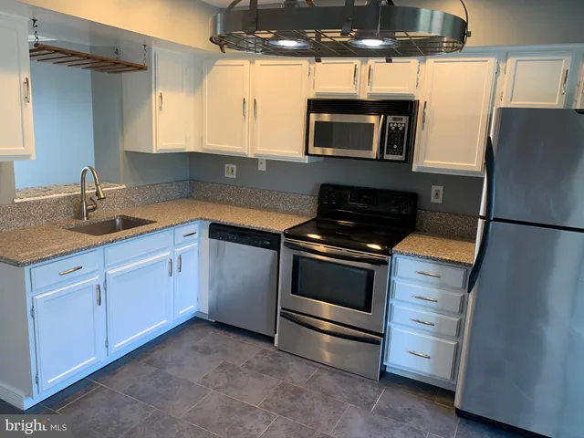 a kitchen with appliances a sink and cabinets