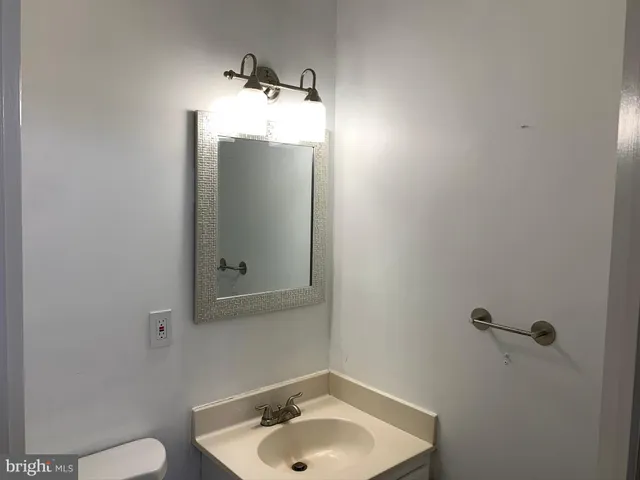 a bathroom with a sink and mirror with toilet