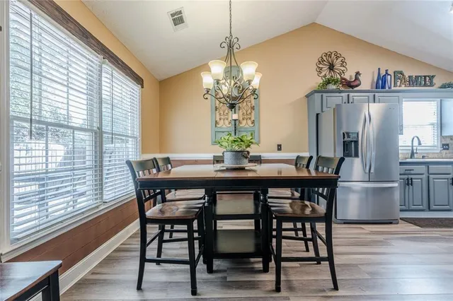 a view of a dining room and livingroom with furniture a chandelier and wooden floor