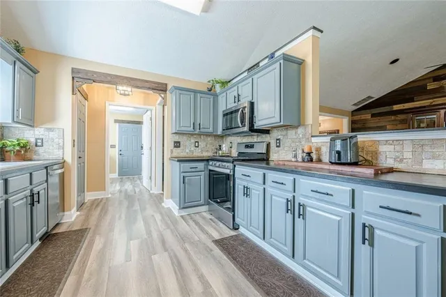 a kitchen with stainless steel appliances granite countertop a stove and a microwave