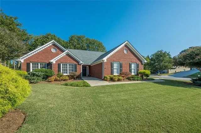 a front view of a house with yard and green space