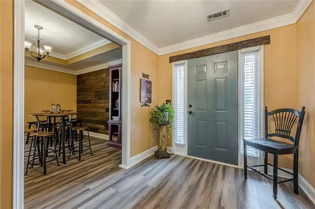 a view of a hallway with wooden floor and dining room