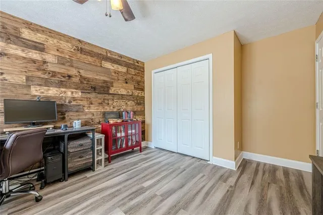 a view of a patio with table and chairs with wooden fence and large trees