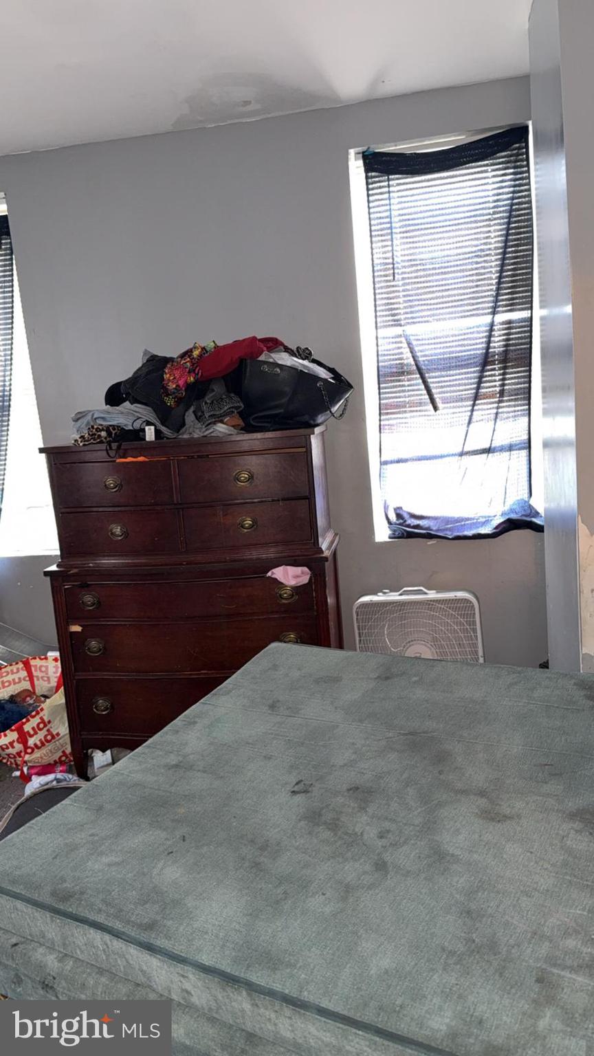 1723 Homestead Street Baltimore, MD 21218 - Photo 23 of 27 a living room with a bed and a dresser next to a window