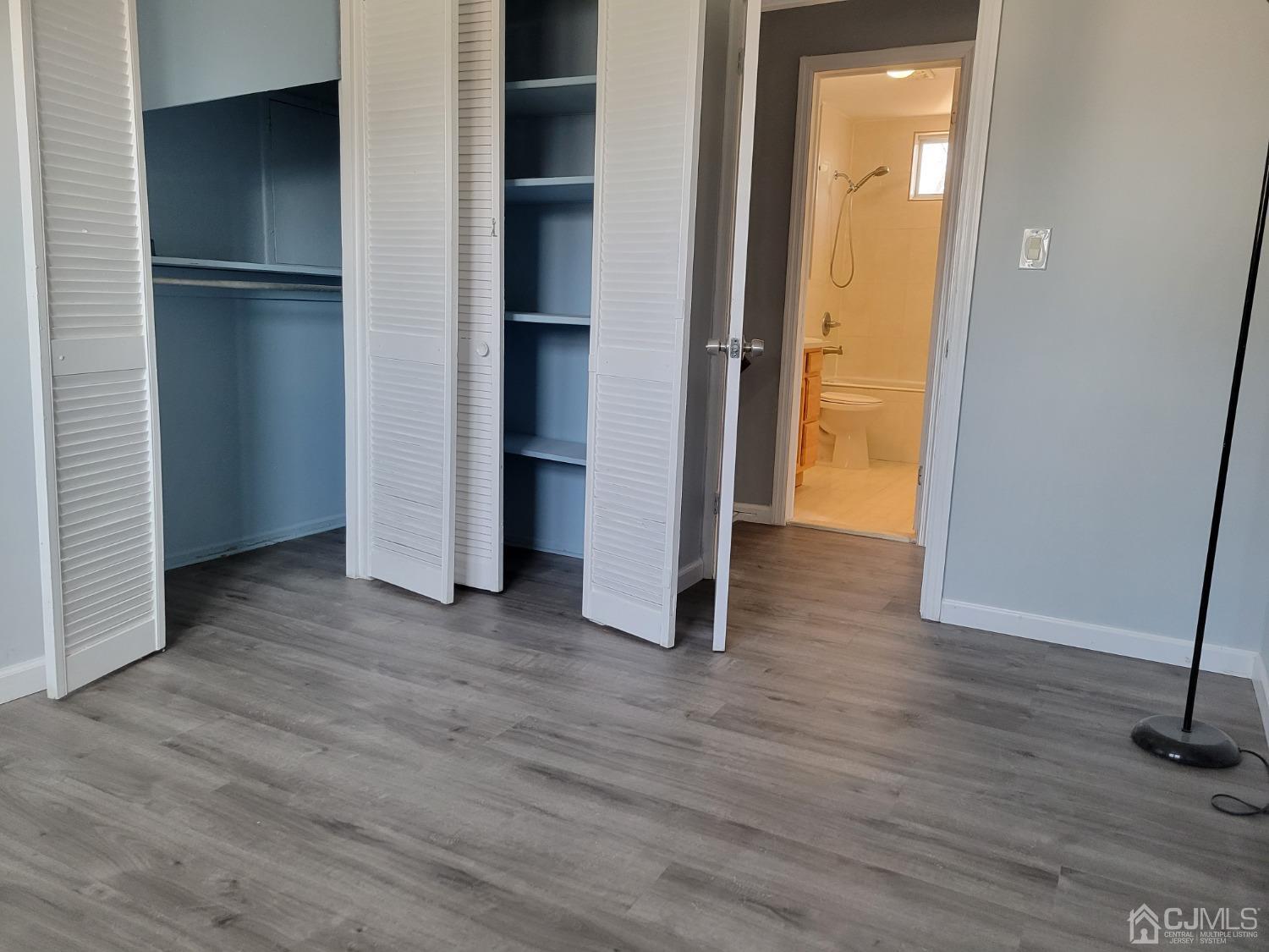 19 Baldwin Road Edison, NJ 08817 - Photo 24 of 36 an empty room with wooden floor and a kitchen