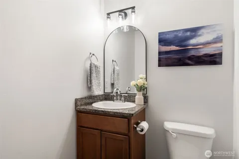 a bathroom with a toilet a sink and mirror
