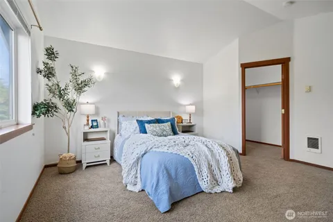 a bedroom with a bed and a potted plant