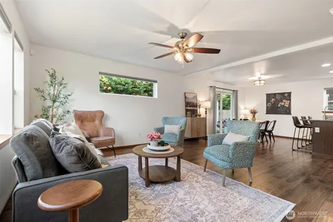 a living room with furniture a rug a lamp and a window