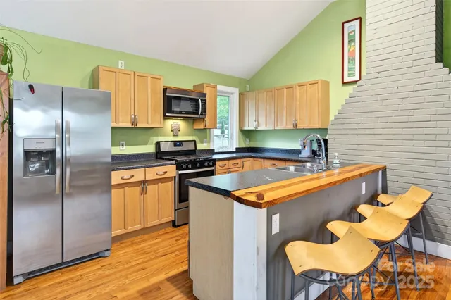 a kitchen with stainless steel appliances a sink a counter top space cabinets and a window