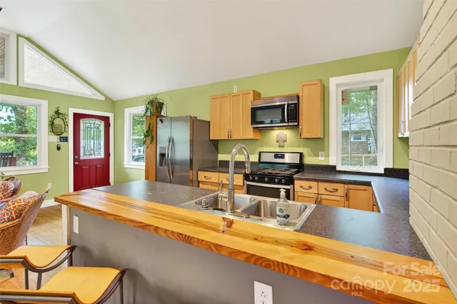 a kitchen with stainless steel appliances granite countertop a sink stove and refrigerator