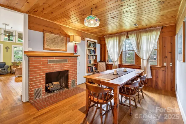 a dining room with furniture window fireplace and wooden floor