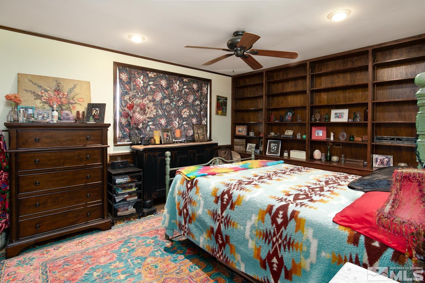 4300 Cox Road Fallon, NV 89406 - Photo 18 of 24 a bedroom with a bed a dresser and book shelf