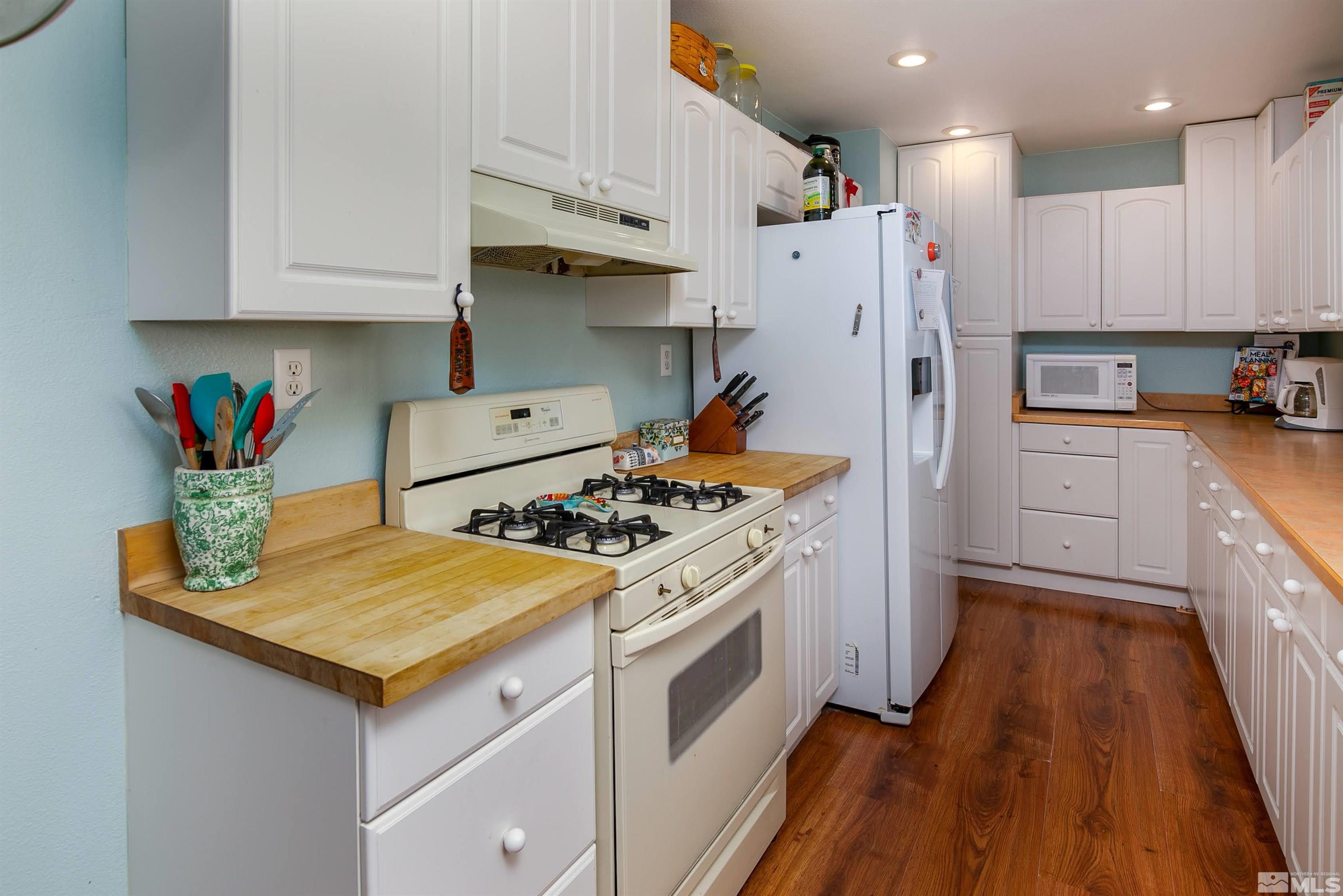4300 Cox Road Fallon, NV 89406 - Photo 4 of 24 a kitchen with stainless steel appliances granite countertop a white stove top oven a sink and white cabinets