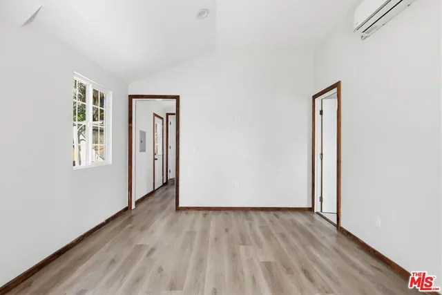 an empty room with wooden floor and a window