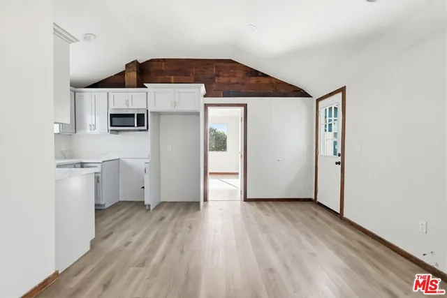a very nice looking room with wooden floor and a cabinet