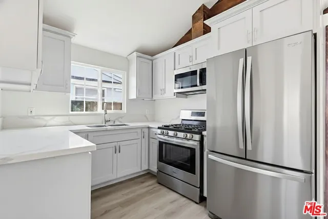a kitchen with stainless steel appliances a refrigerator stove and sink